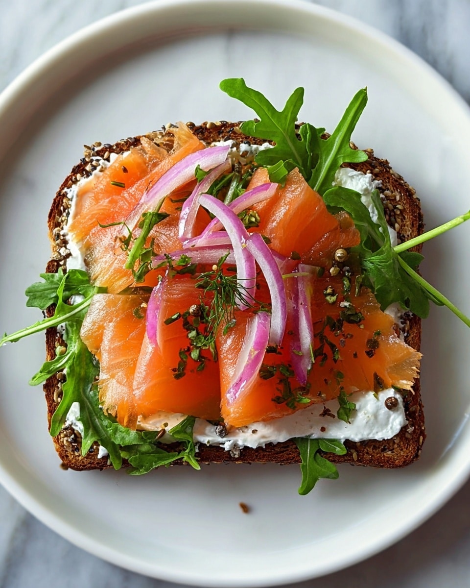 A sandwich with three main layers sits on a rustic wooden board with some sea salt flakes around it, all on a white marbled texture. The bottom layer is a thick slice of seeded bread with a dark golden crust, topped with a thick spread of white cream cheese. Above that is a layer of fresh green arugula leaves, their edges crisp and wavy. The next layer features folded, glossy slices of pink-orange smoked salmon, slightly translucent with natural marbling. On top of the salmon are thin, curved rings of bright purple-red onion, and a few more arugula leaves peek out around the edges. The sandwich is finished with a matching top piece of seeded bread, golden with a crust covered in mixed seeds and sliced almonds. Photo taken with an iphone --ar 4:5 --v 7