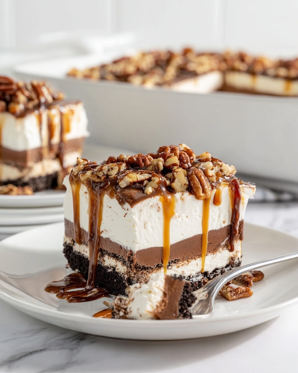 A square slice of layered dessert sits on a white plate with a white marbled texture below. The dessert has four visible layers: the bottom layer is a dark, crumbly cookie crust; above it is a thick, white creamy layer; the middle layer is smooth and rich chocolate; followed by another white creamy layer. The top is covered in chopped pecans and drizzled with dark chocolate and golden caramel sauce, which drips slightly down the sides. In the background, there is a white dish showing more of the dessert and another white plate with a similar slice. Photo taken with an iphone --ar 4:5 --v 7