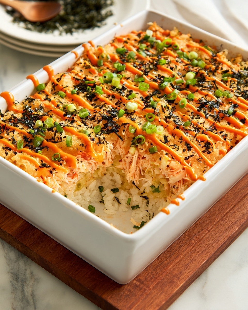 A baked casserole in a white rectangular dish with a golden-orange top layer covered with drizzles of bright orange and dark red sauces, sprinkled with black sesame seeds and small chopped green onions, creating a colorful and textured surface. The casserole's edges show some crispy, browned spots from baking. Beside the dish lies a yellow-orange bottle of Sriracha mayo with a red cap, on a white marbled surface scattered with bits of green onions and sesame seeds. Photo taken with an iphone --ar 4:5 --v 7