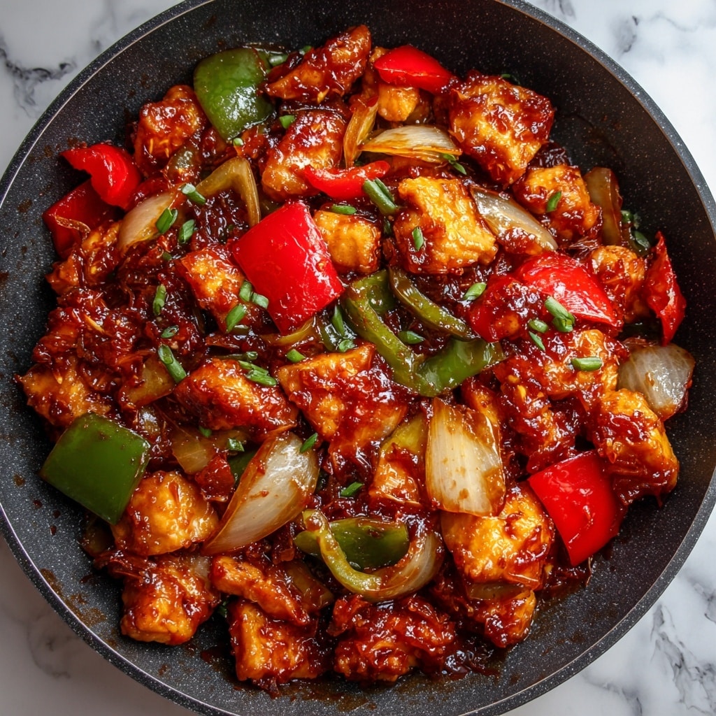 The image shows a close-up of a dark pan filled with a saucy dish made of multiple textured layers. There are small pieces of cooked chicken in light brown, soft, and juicy with a glossy red-brown sauce covering them. Mixed with the chicken are chopped green and red bell peppers, which are shiny and soft but keep their shape, and large chunks of translucent cooked onions that add a light creamy tone. The rich sauce coats all the ingredients evenly, creating a sticky and shiny surface. The background is a white marbled texture. photo taken with an iphone --ar 4:5 --v 7