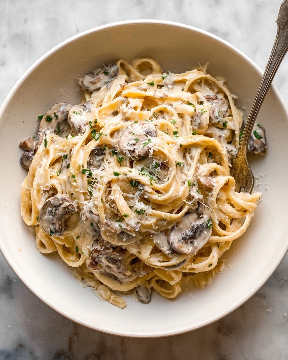 The image shows a close-up of a creamy mushroom sauce in a white pot with a red edge, resting on a white marbled surface. The sauce is thick and off-white with small bits of green herbs and black pepper mixed in. Sliced brown mushrooms are scattered throughout the sauce, visible both in the pot and on the wooden spoon resting inside it, which is partially covered with the sauce. The texture of the sauce looks smooth and rich, while the mushrooms add some chunkiness to it. Photo taken with an iphone --ar 4:5 --v 7