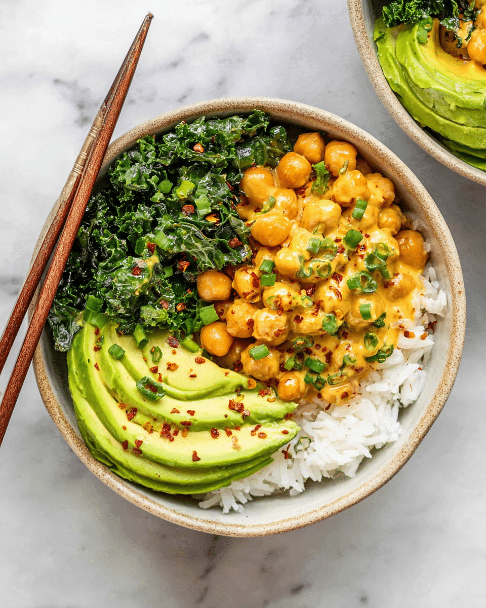 In a white bowl, the bottom layer is fluffy white rice, topped on one side with bright green sliced avocado and dark leafy kale with a slightly rough texture. The main center layer is creamy chickpeas coated in a warm orange sauce, sprinkled with chopped green herbs and red chili flakes. Dark brown wooden chopsticks rest on the left side of the bowl. The bowl sits on a white marbled surface. photo taken with an iphone --ar 4:5 --v 7