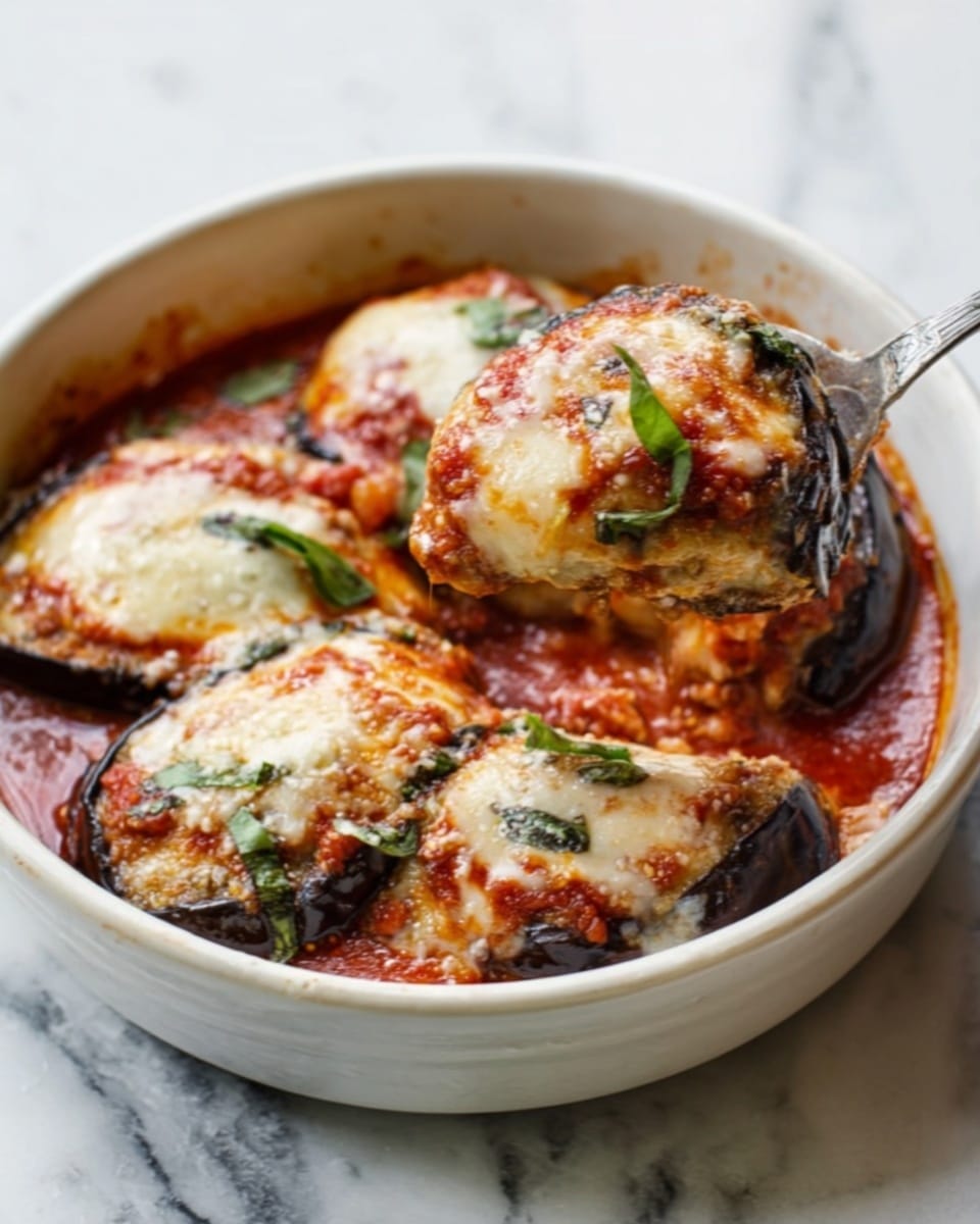 The image shows a white baking dish filled with baked stuffed pasta rolls covered in a bright red tomato sauce. Each roll is layered with visible melted cheese on top that has golden brown spots from baking. Fresh green basil leaves are scattered on top, adding a touch of color. There are slices of grilled or roasted yellow and dark purple vegetables arranged neatly between the pasta rolls. A woman's hand holds a wooden spoon lifting one stuffed roll, showing the soft cheesy and saucy inside. The dish sits on a white marbled surface with a thin red and white striped cloth nearby. photo taken with an iphone --ar 4:5 --v 7